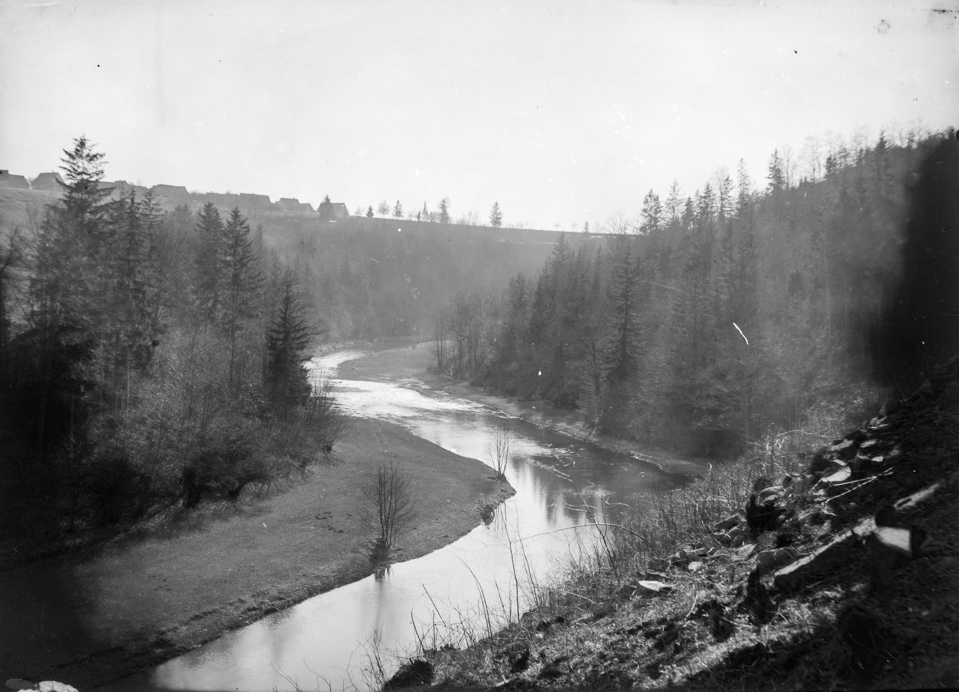 Flusslandschaft mit Tal und bewaldeten Hängen